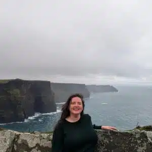 Carly Fielding, Marketing Assistant, standing at the Cliffs of Moher in Ireland